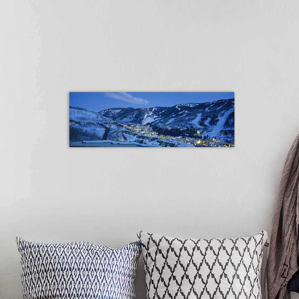 A bohemian room featuring Panoramic photograph of a  snowy mountain landscape surrounding the brightly lit town of Tellurid...