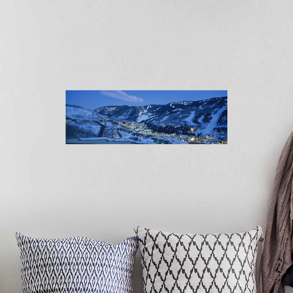 A bohemian room featuring Panoramic photograph of a  snowy mountain landscape surrounding the brightly lit town of Tellurid...