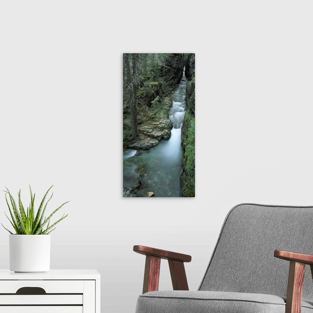 A modern room featuring Panoramic vertical image that looks downward on a waterfall whose water flows from a cave.