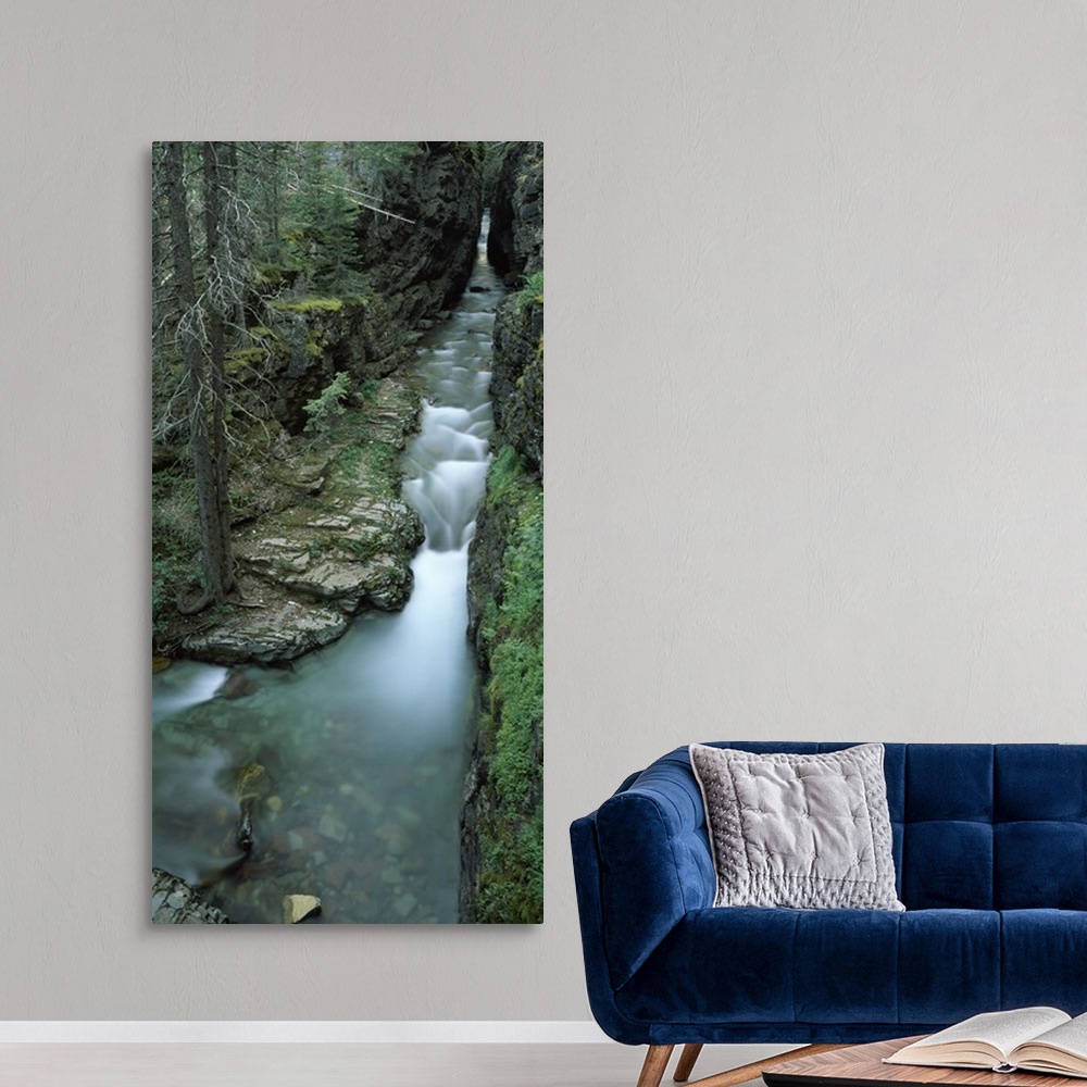 A modern room featuring Panoramic vertical image that looks downward on a waterfall whose water flows from a cave.