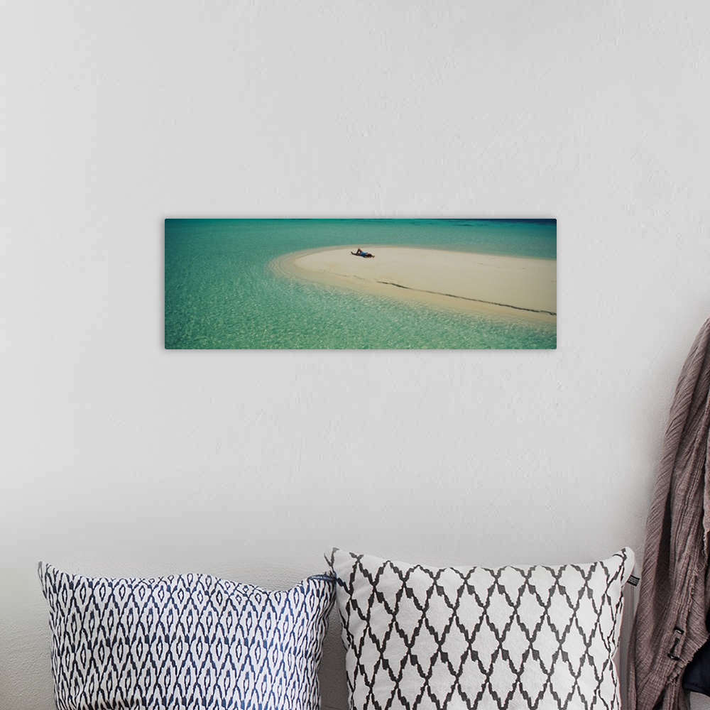 A bohemian room featuring Panoramic photograph of girl tanning on sand bar surrounded by crystal clear ocean.