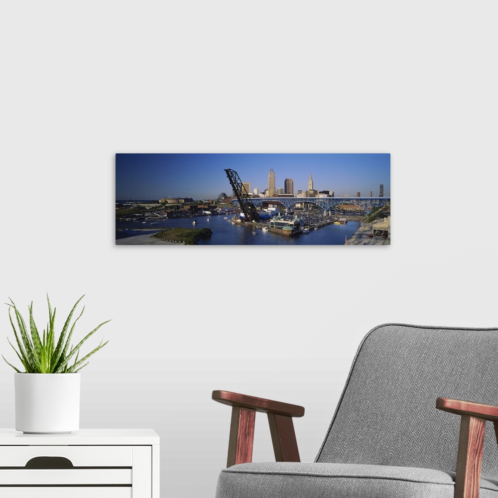 A modern room featuring Panoramic photograph of bridge with port and sailboats below with skyline in the distance under a...