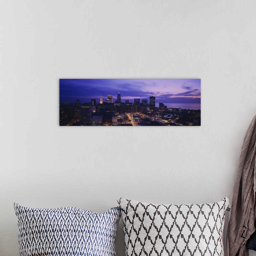 A bohemian room featuring Panoramic, large photograph from a high angle of the Cleveland skyline, with lit buildings at night.