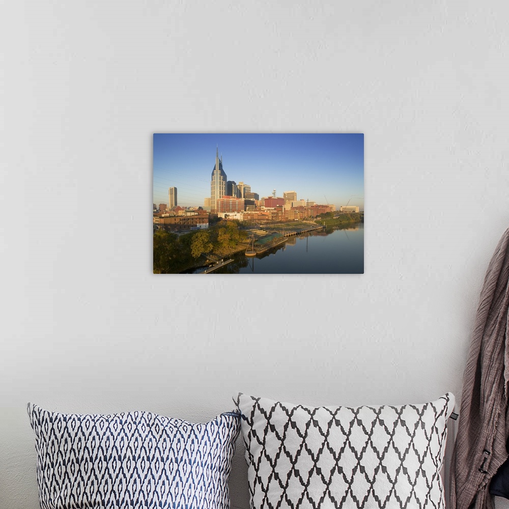 A bohemian room featuring This oversize piece is a photograph taken of the skyline in Nashville that sits along a body of w...