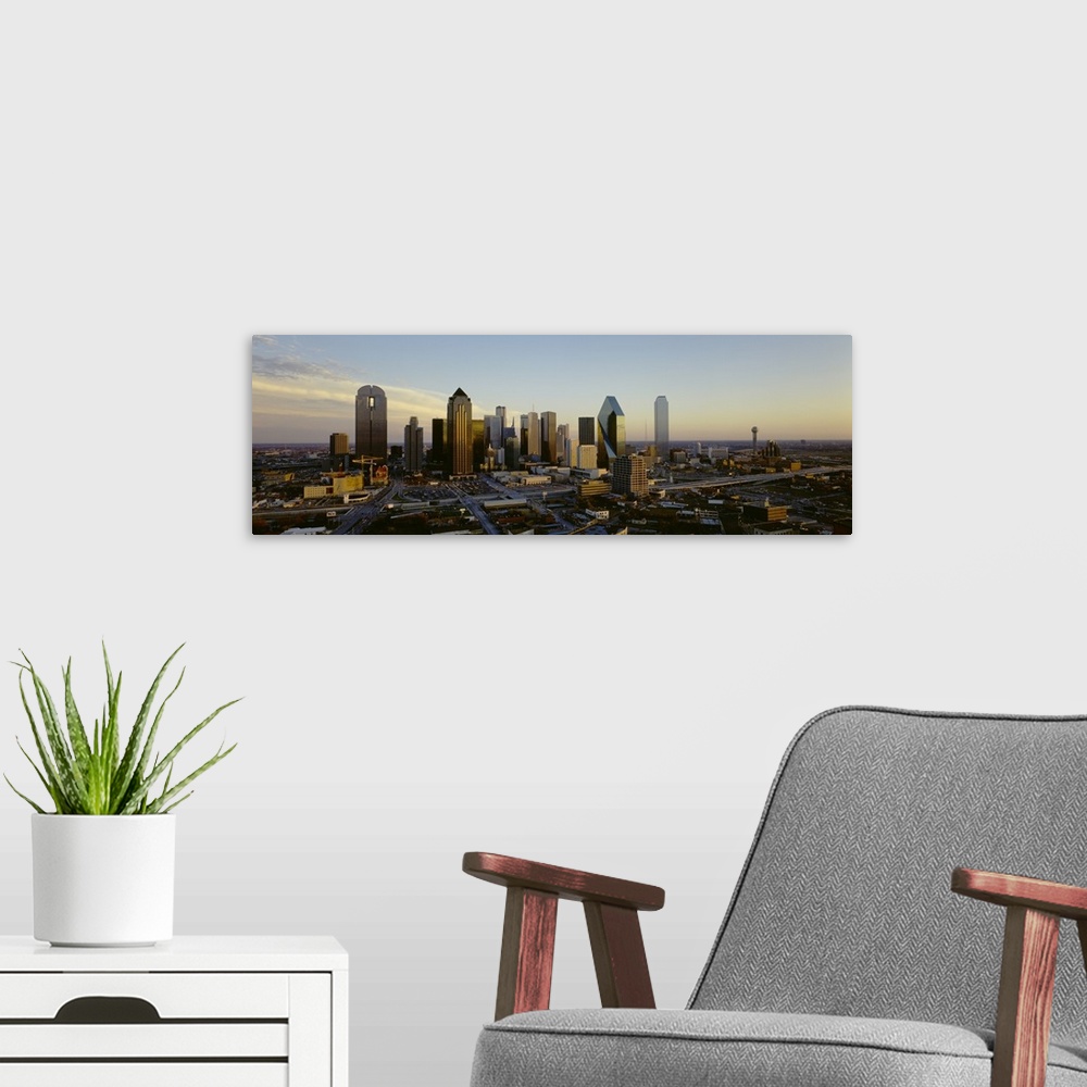 A modern room featuring Buildings in the Dallas skyline are photographed in panoramic view during dawn.