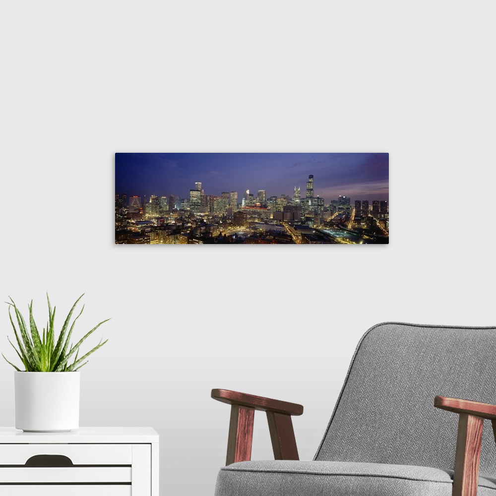 A modern room featuring Panoramic photograph taken of downtown Chicago during the night with all the building windows ill...