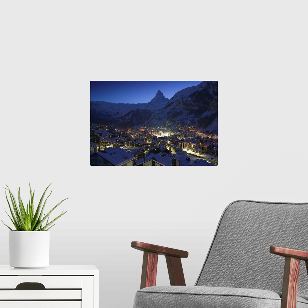 A modern room featuring Photograph of city from above at night with snow covered foothills in the distance.
