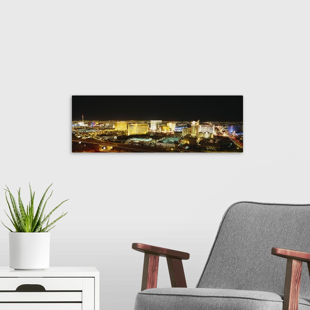 A modern room featuring Panoramic, high angle photograph of brightly lit buildings of the Las Vegas skyline, in Nevada.