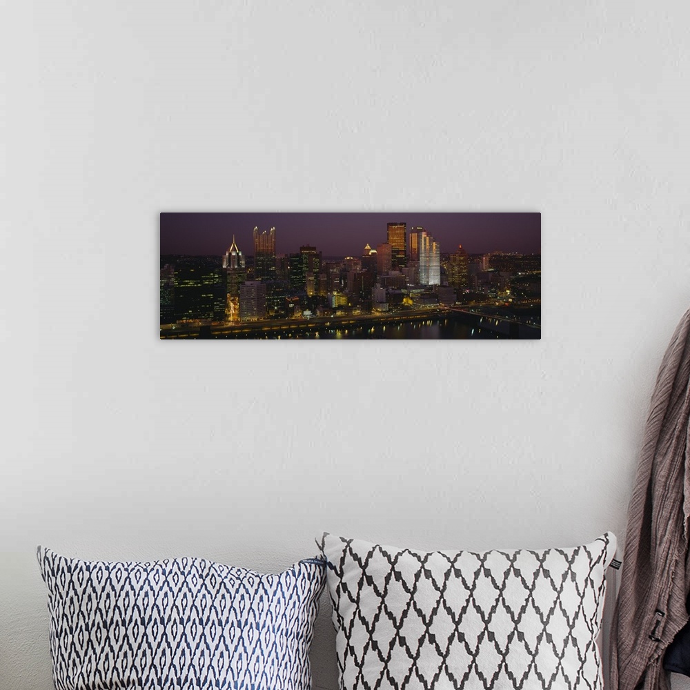 A bohemian room featuring Panoramic photograph of skyline at dusk with tall buildings and skyscrapers glowing in the dark sky.