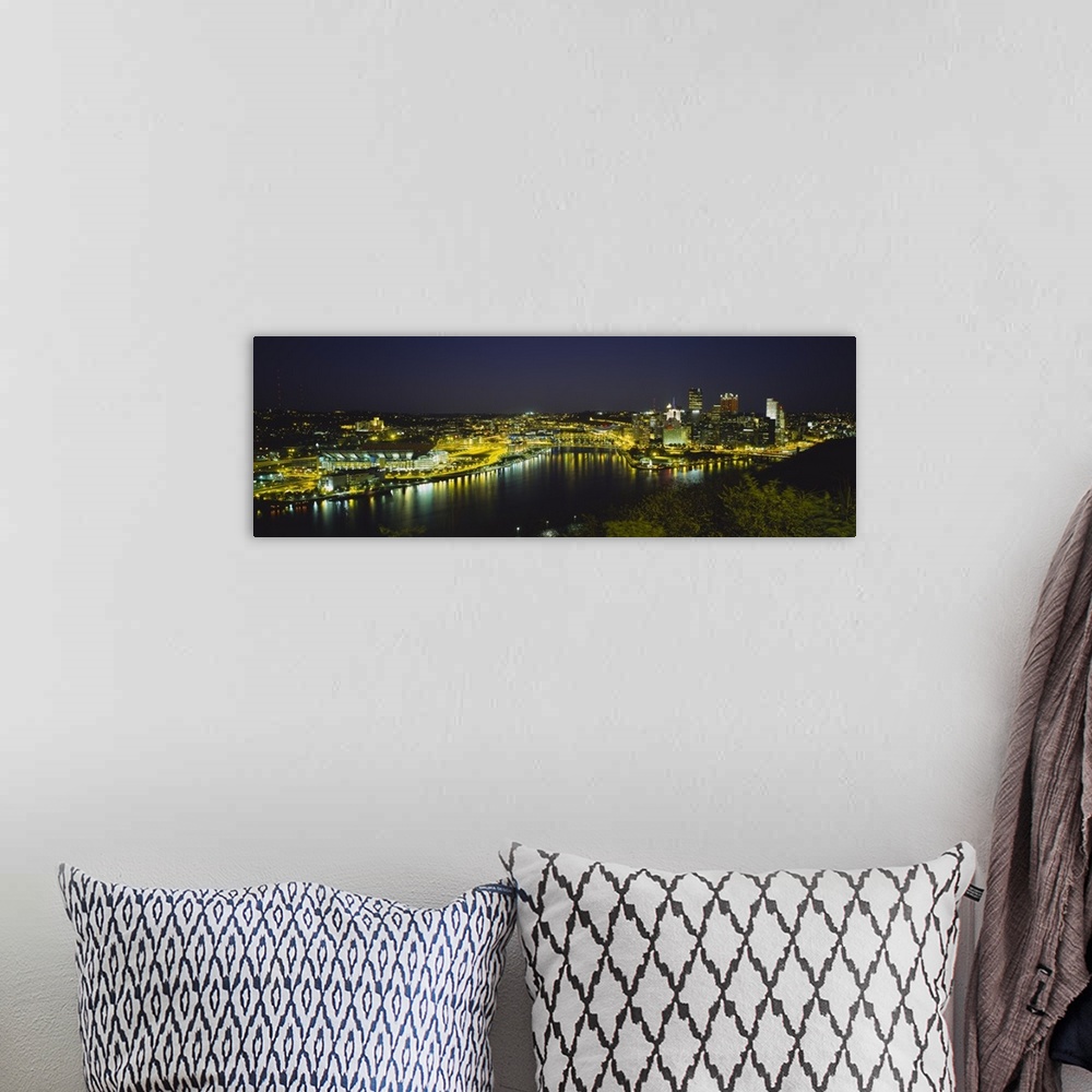 A bohemian room featuring Panoramic photograph of skyline and waterfront at dusk with tree tops in foreground.