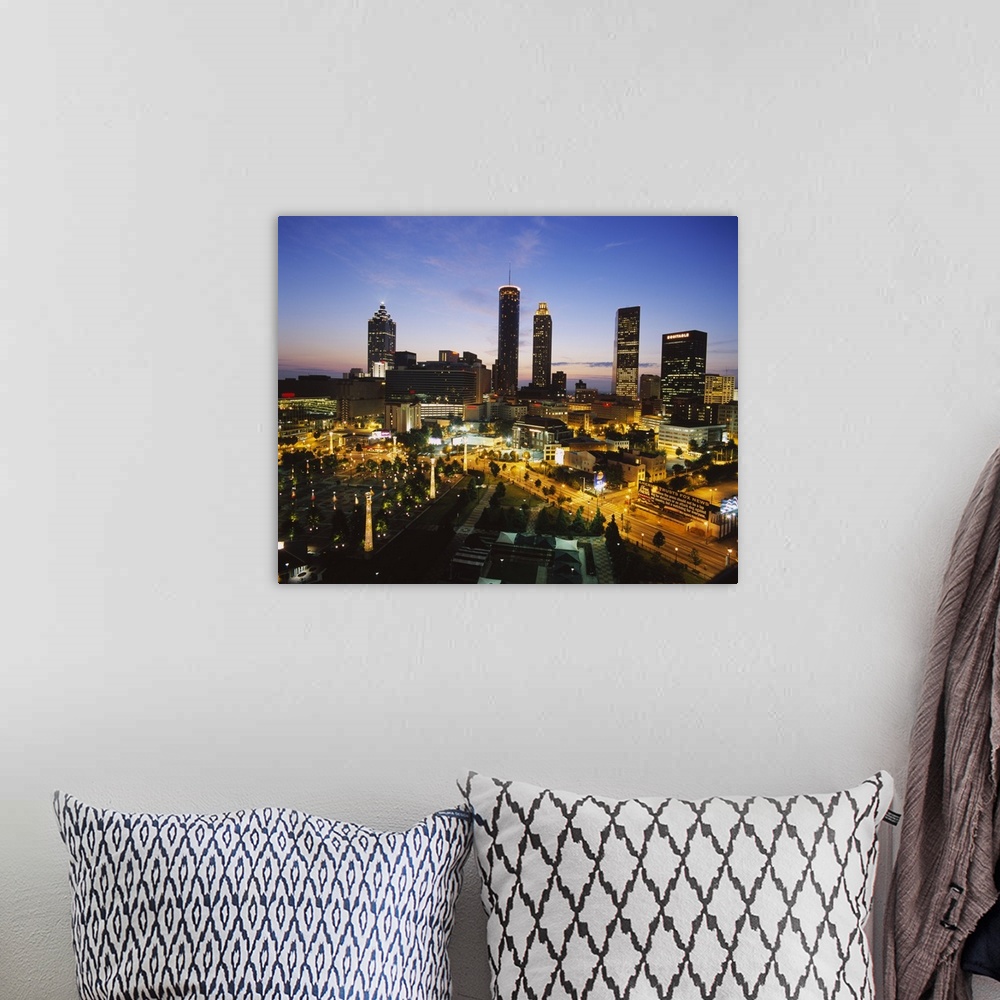 A bohemian room featuring Big photograph taken as the sun begins to set displays brightly shining skyscrapers and buildings...