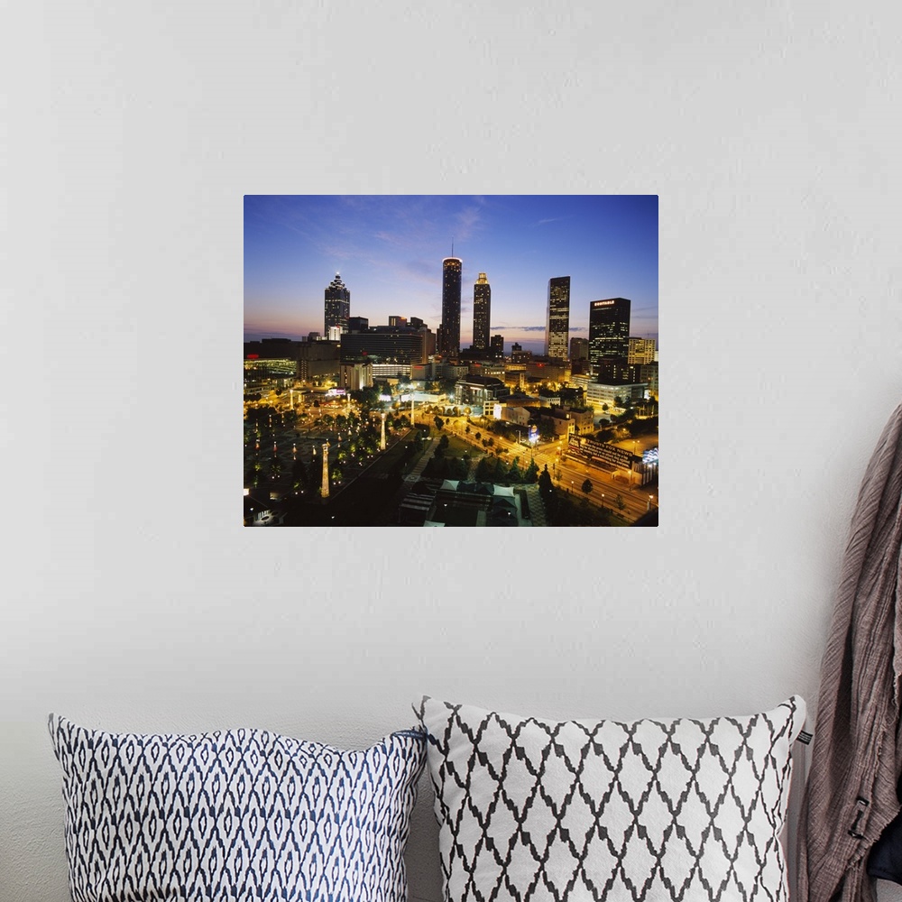A bohemian room featuring Big photograph taken as the sun begins to set displays brightly shining skyscrapers and buildings...