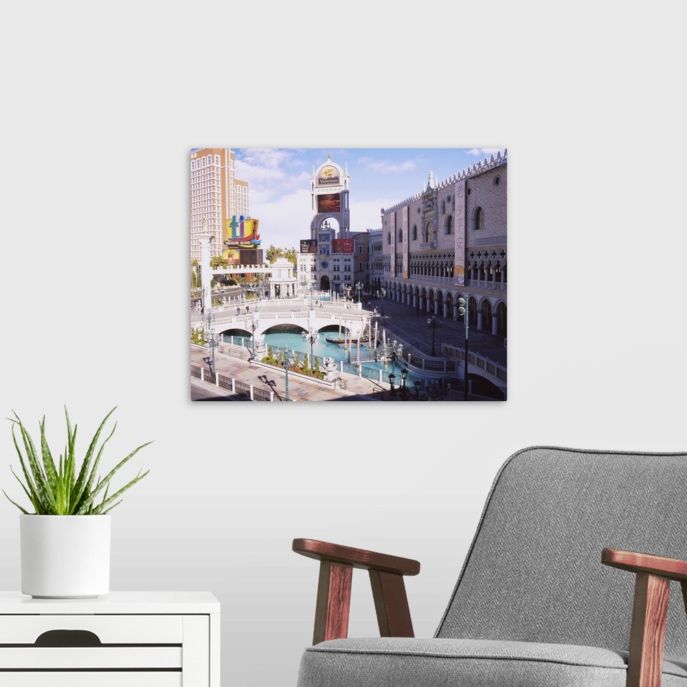 A modern room featuring High angle view of footbridge over a pond in front of buildings, Venetian Hotel, Treasure Island ...