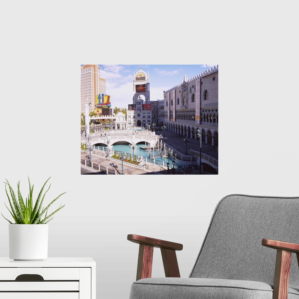 A modern room featuring High angle view of footbridge over a pond in front of buildings, Venetian Hotel, Treasure Island ...