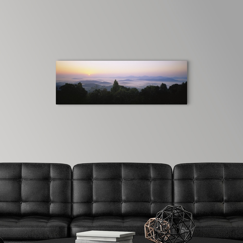 A modern room featuring Large panoramic photograph of mountains in Virginia with the sun setting far in the distance and ...