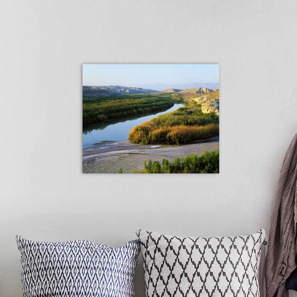 A bohemian room featuring This photograph was taken inside Big Bend national park showing the river that has large brush li...