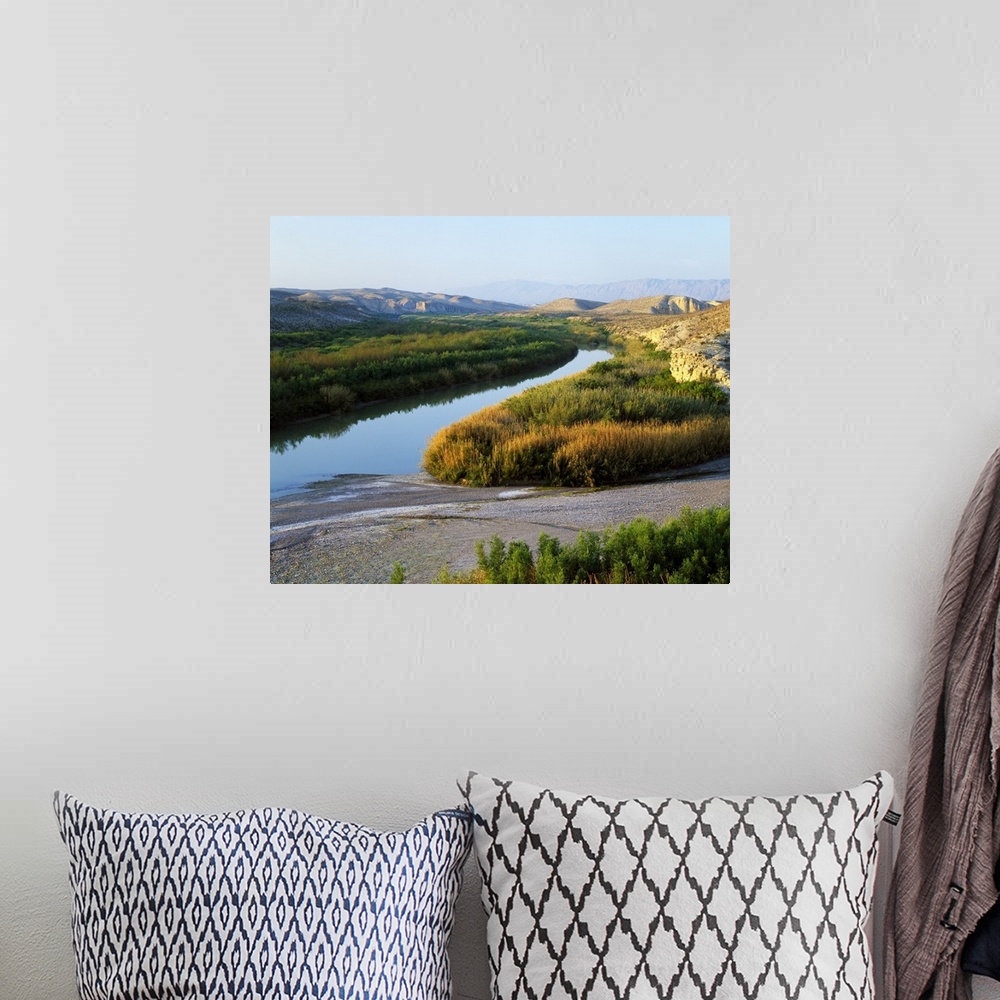 A bohemian room featuring This photograph was taken inside Big Bend national park showing the river that has large brush li...