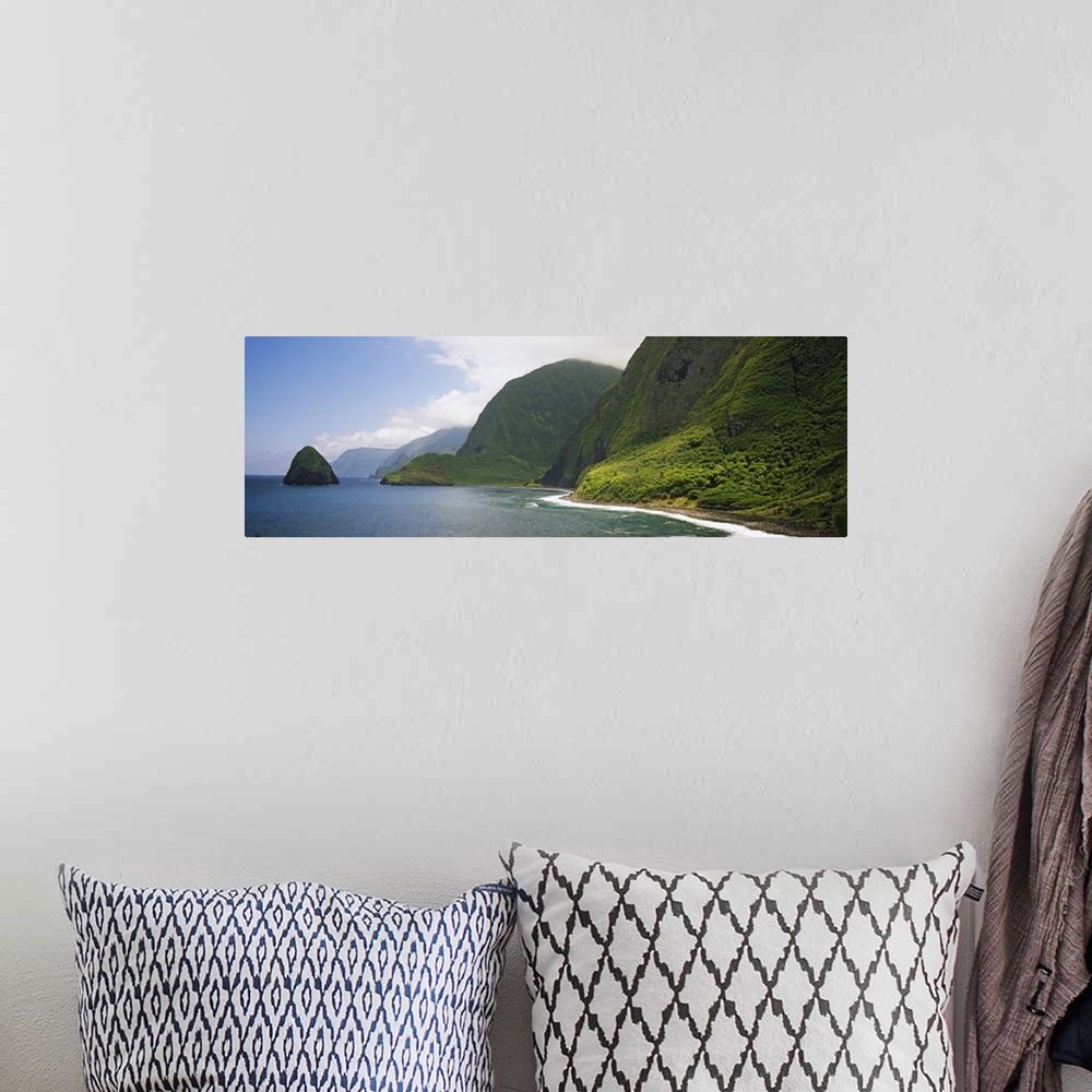 A bohemian room featuring Wide angle photograph taken of immense cliffs that line the coast of a Hawaiian island.