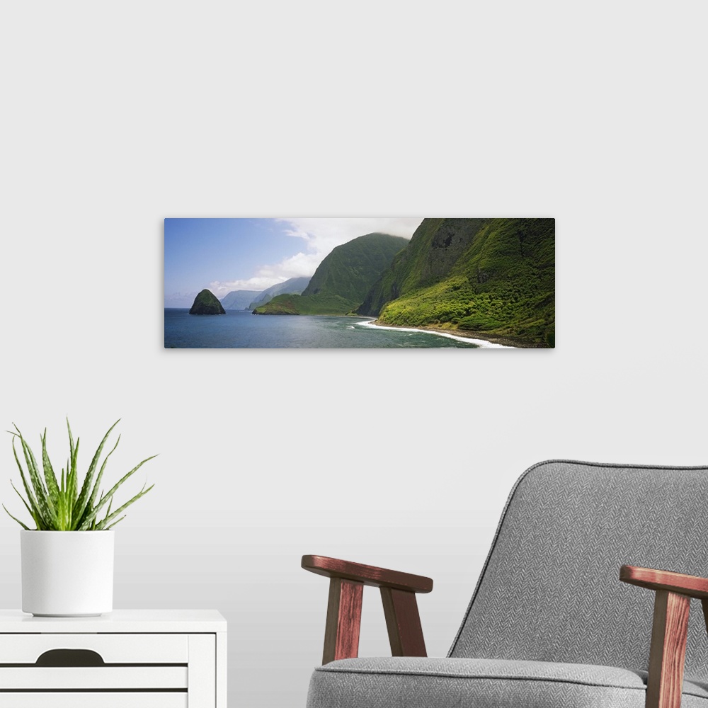A modern room featuring Wide angle photograph taken of immense cliffs that line the coast of a Hawaiian island.