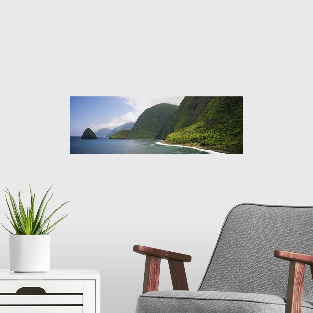 A modern room featuring Wide angle photograph taken of immense cliffs that line the coast of a Hawaiian island.
