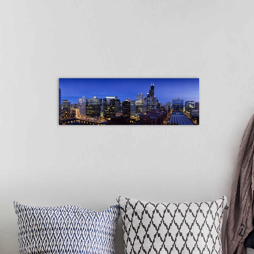 A bohemian room featuring Panoramic photograph at nighttime displays the bright buildings and high-rises that hover over th...