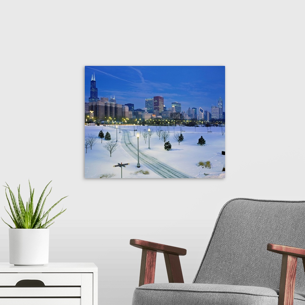 A modern room featuring A photograph of a city park buried in fresh snow and the city skyscrapers available of as a large...