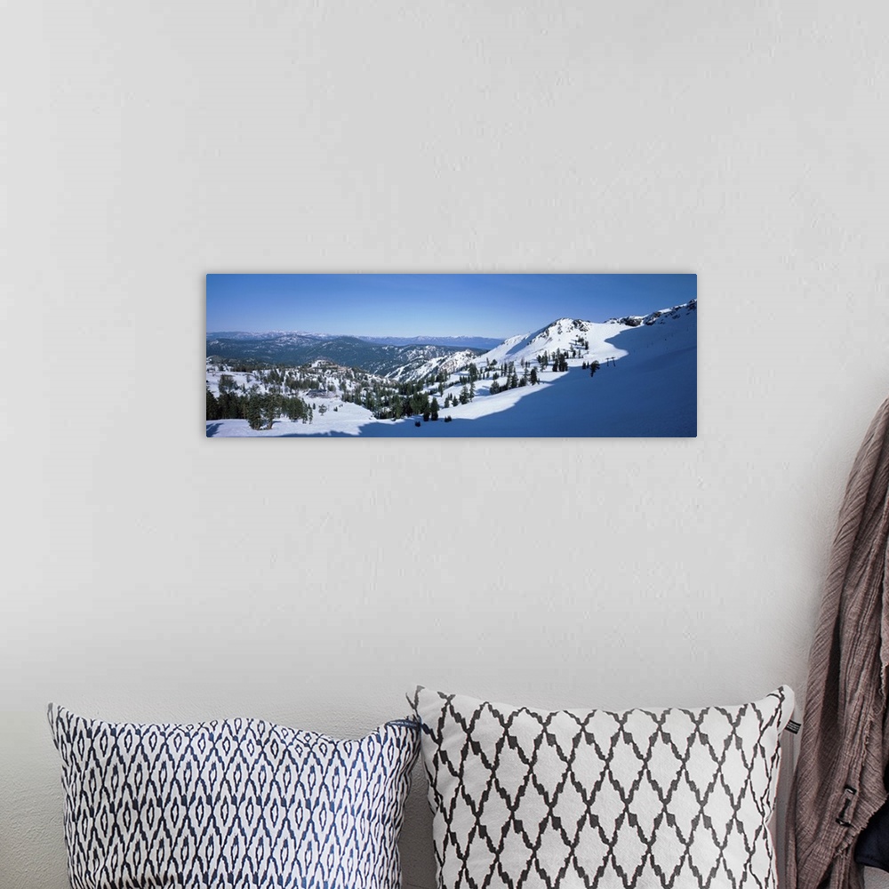 A bohemian room featuring A panoramic photograph looking down a snow covered mountain into the valley below.