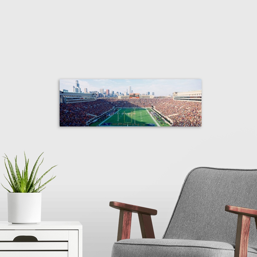 A modern room featuring Panoramic photograph of a football stadium with the stands packed with fans ready to watch the Ch...