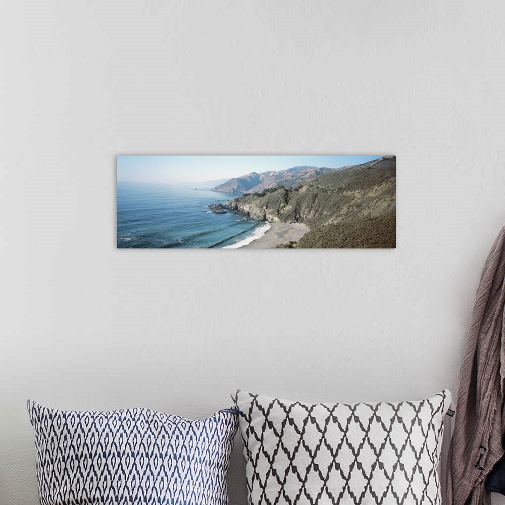 A bohemian room featuring Panoramic image of the Pacific Ocean meeting rocky cliffs and a smooth beach.