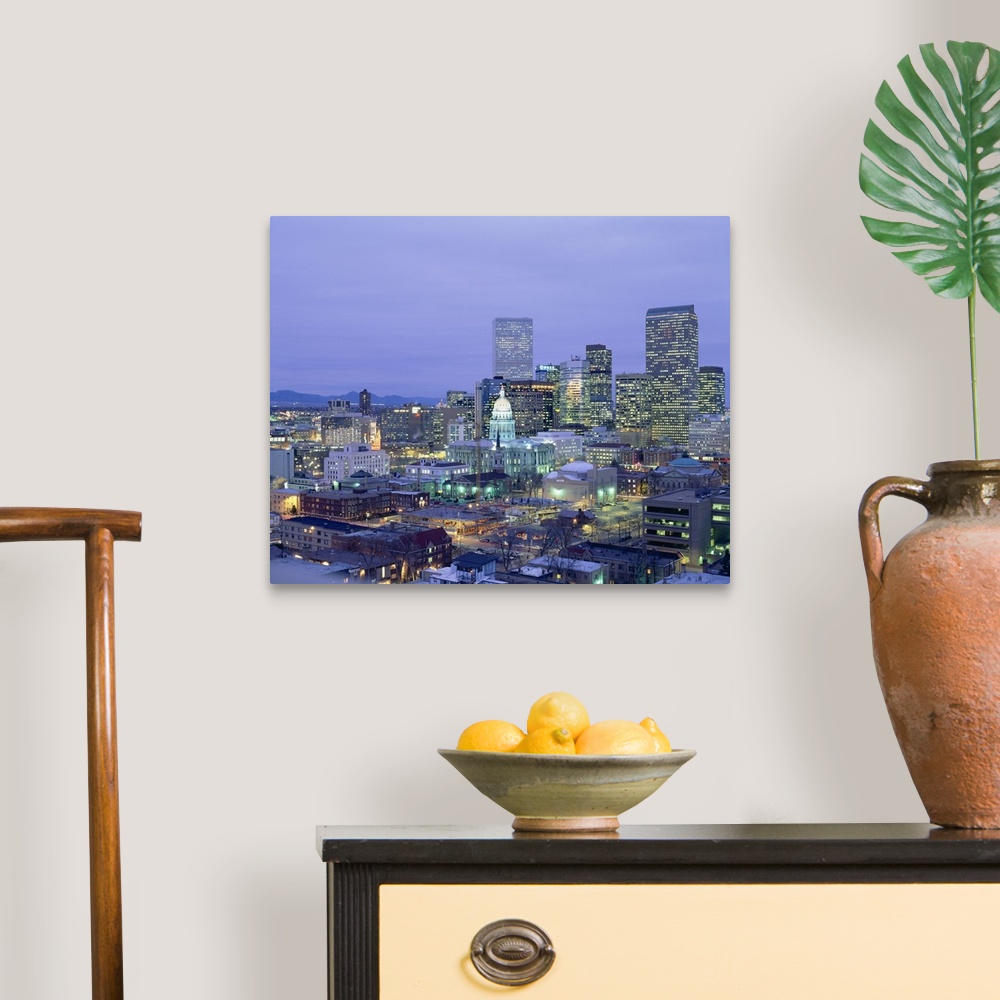 A traditional room featuring Square canvas photo of a illuminated city at dusk with mountains in the left background.