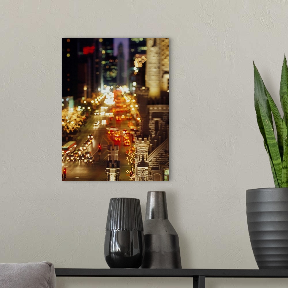 A modern room featuring Vertical panoramic photograph of busy street lined with tall buildings that are lit up in the nig...