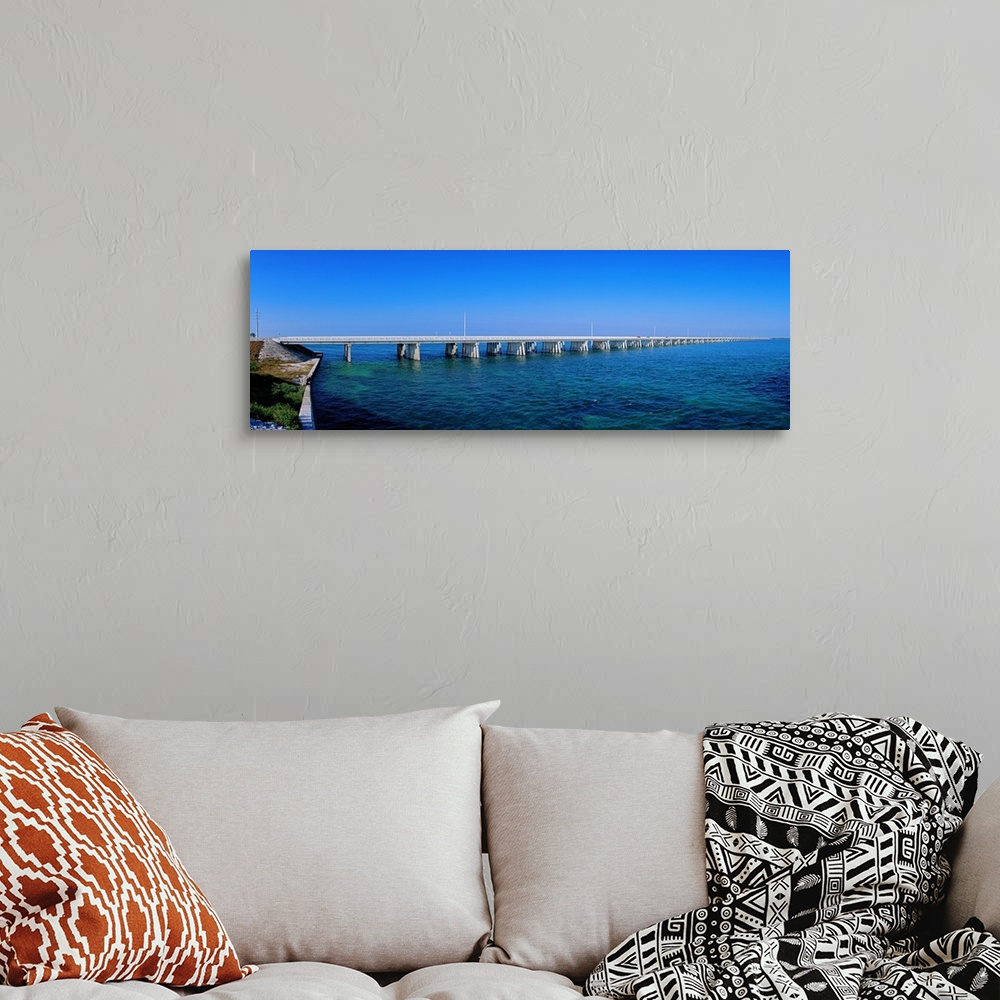 A bohemian room featuring Big panoramic photo print of a long bridge going over the ocean.