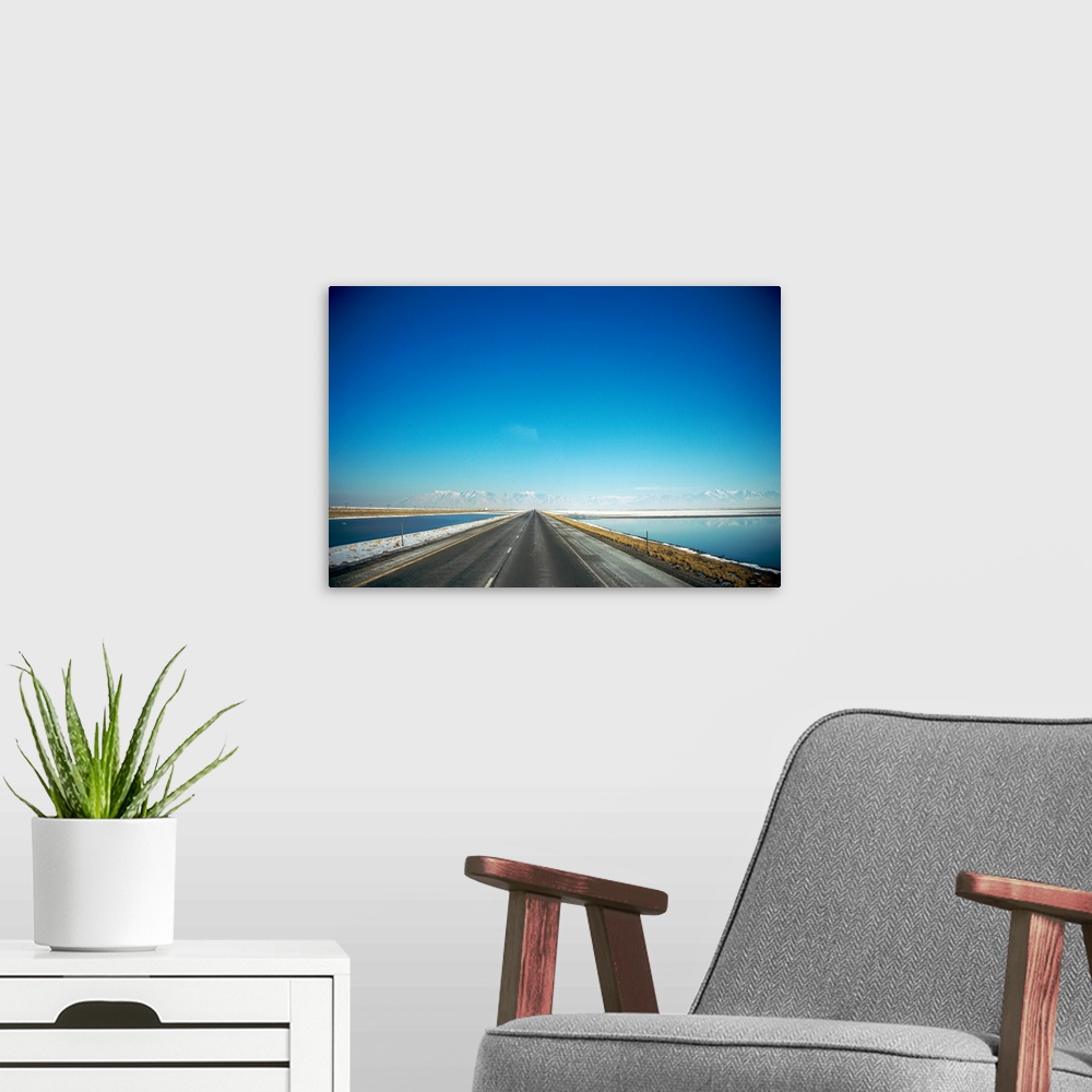 A modern room featuring Highway along a lake with snow covered mountains in the background, Interstate 80, Tooele County,...