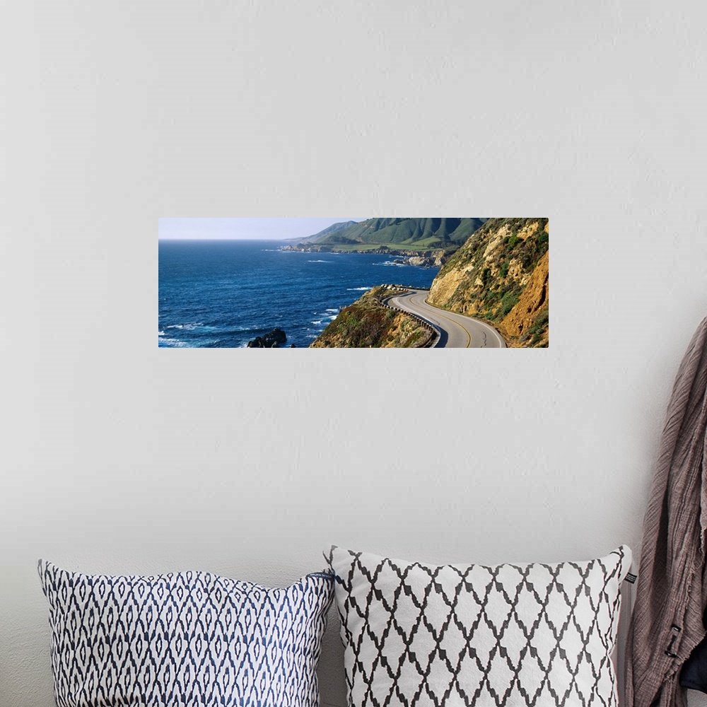A bohemian room featuring Big, panoramic landscape photograph of curving Route 1 on a hillside, along the coast of Big Sur,...