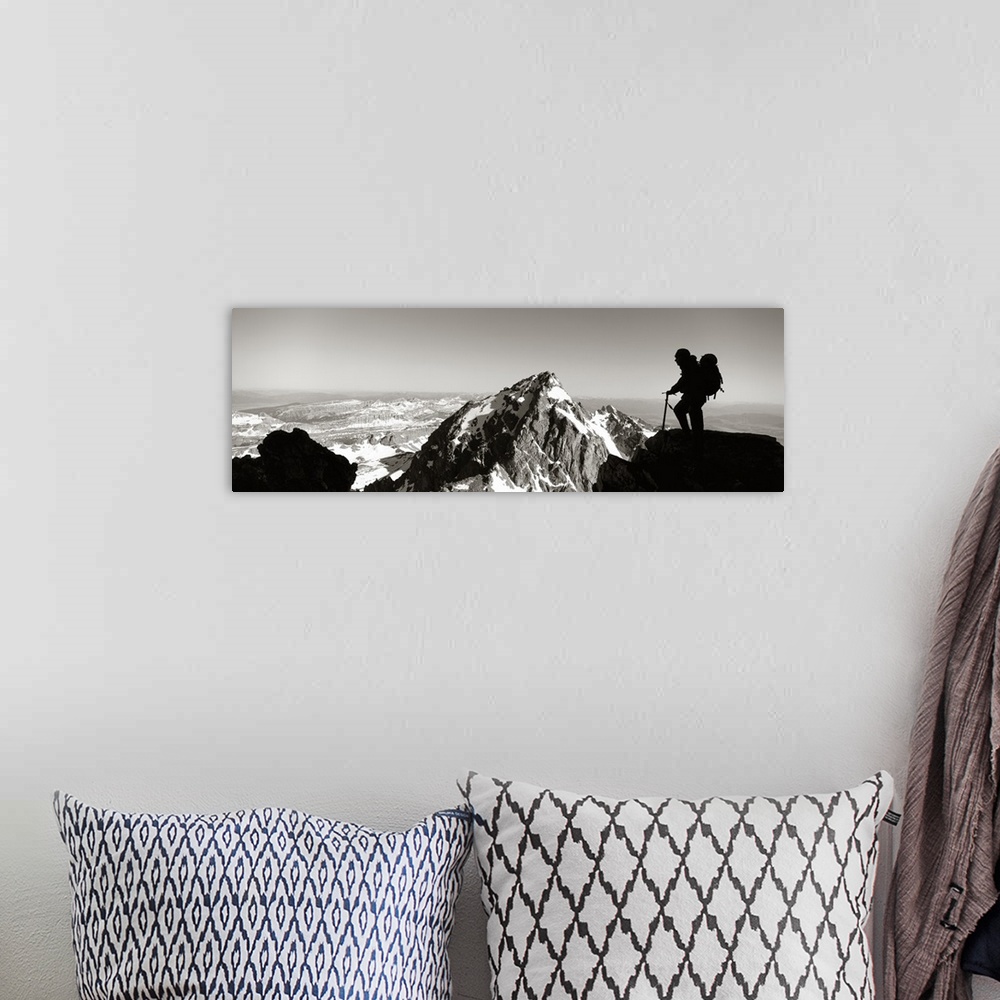 A bohemian room featuring This panoramic photograph shows mountain peaks and the silhouette of a climber surveying the land...