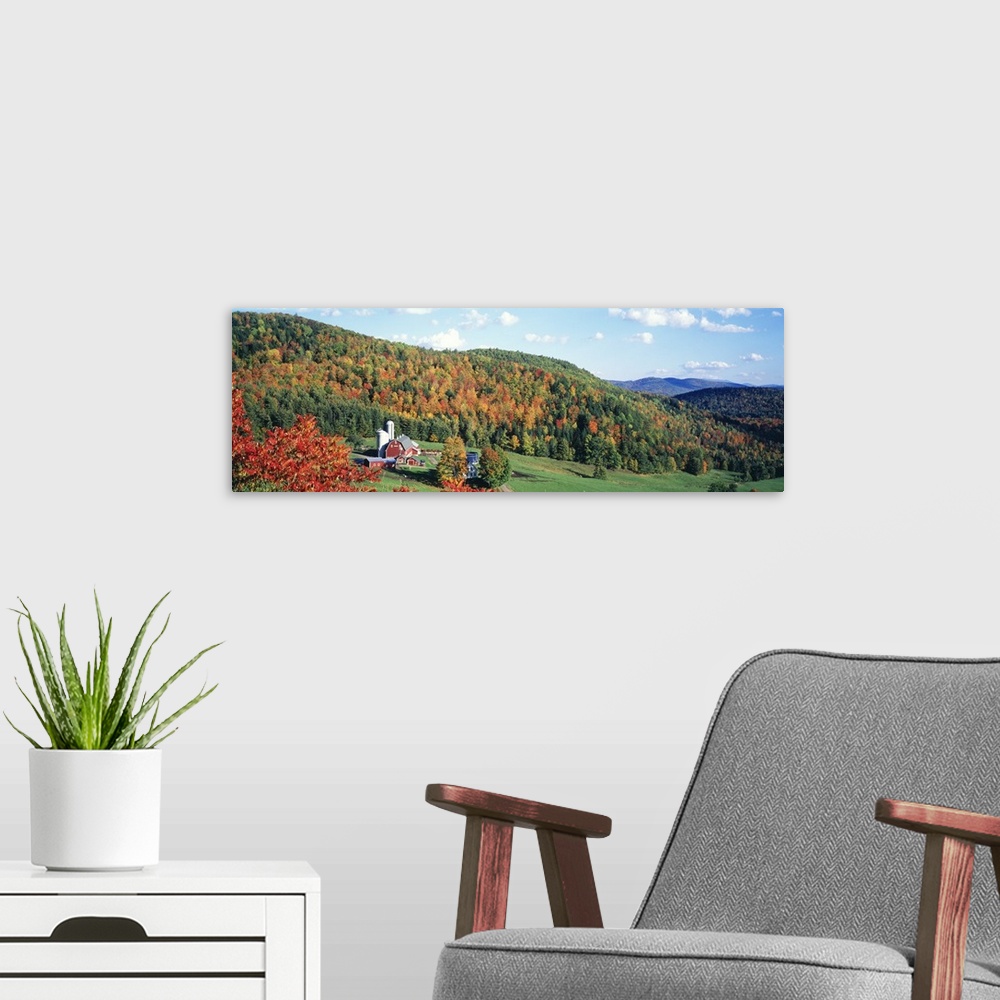 A modern room featuring This decorative wall accent for the home or workspace is a panoramic photograph of a farm in the ...