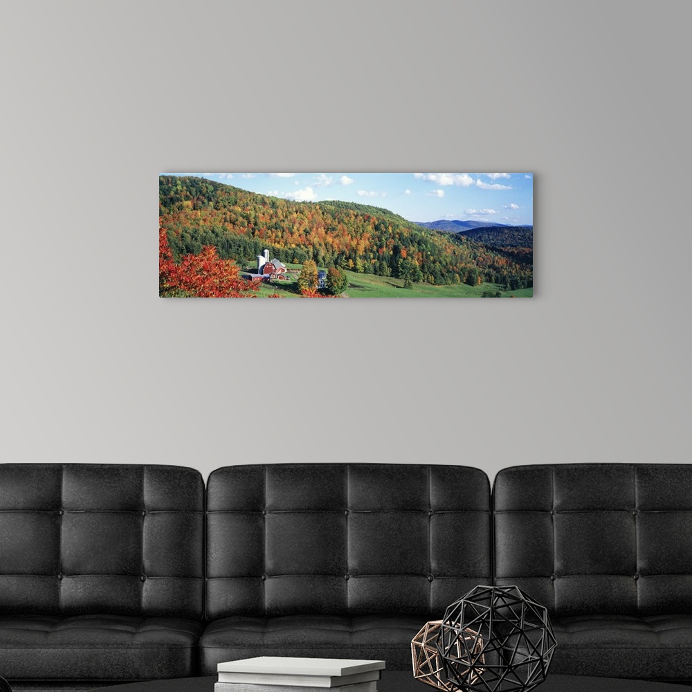 A modern room featuring This decorative wall accent for the home or workspace is a panoramic photograph of a farm in the ...