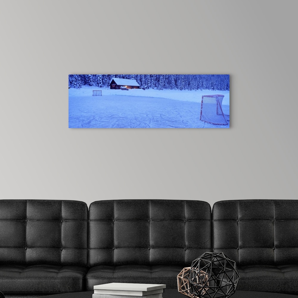 A modern room featuring Wall art for the home or cabin this panoramic photograph shows a cabin buried in snow next to a f...