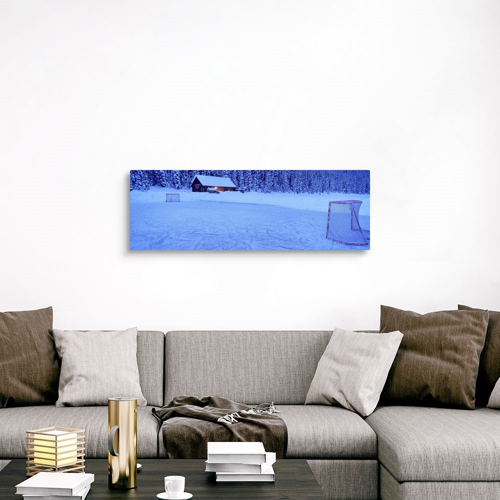 A traditional room featuring Wall art for the home or cabin this panoramic photograph shows a cabin buried in snow next to a f...