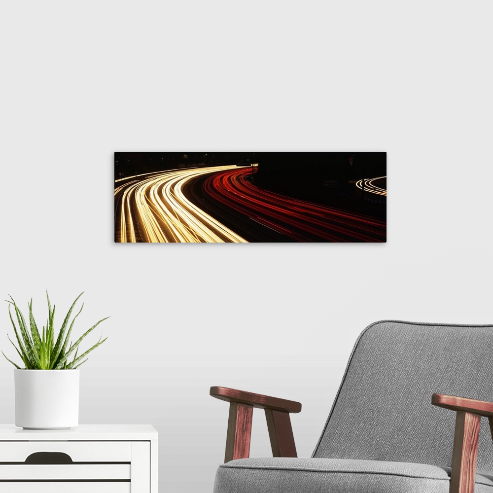 A modern room featuring Trails of car lights on the busy Hollywood Freeway in the evening in California.