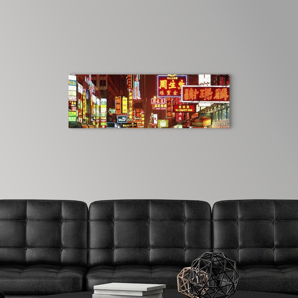 A modern room featuring Wide angle photograph on a large canvas of many brightly lit neon signs, at night in Hong Kong, C...