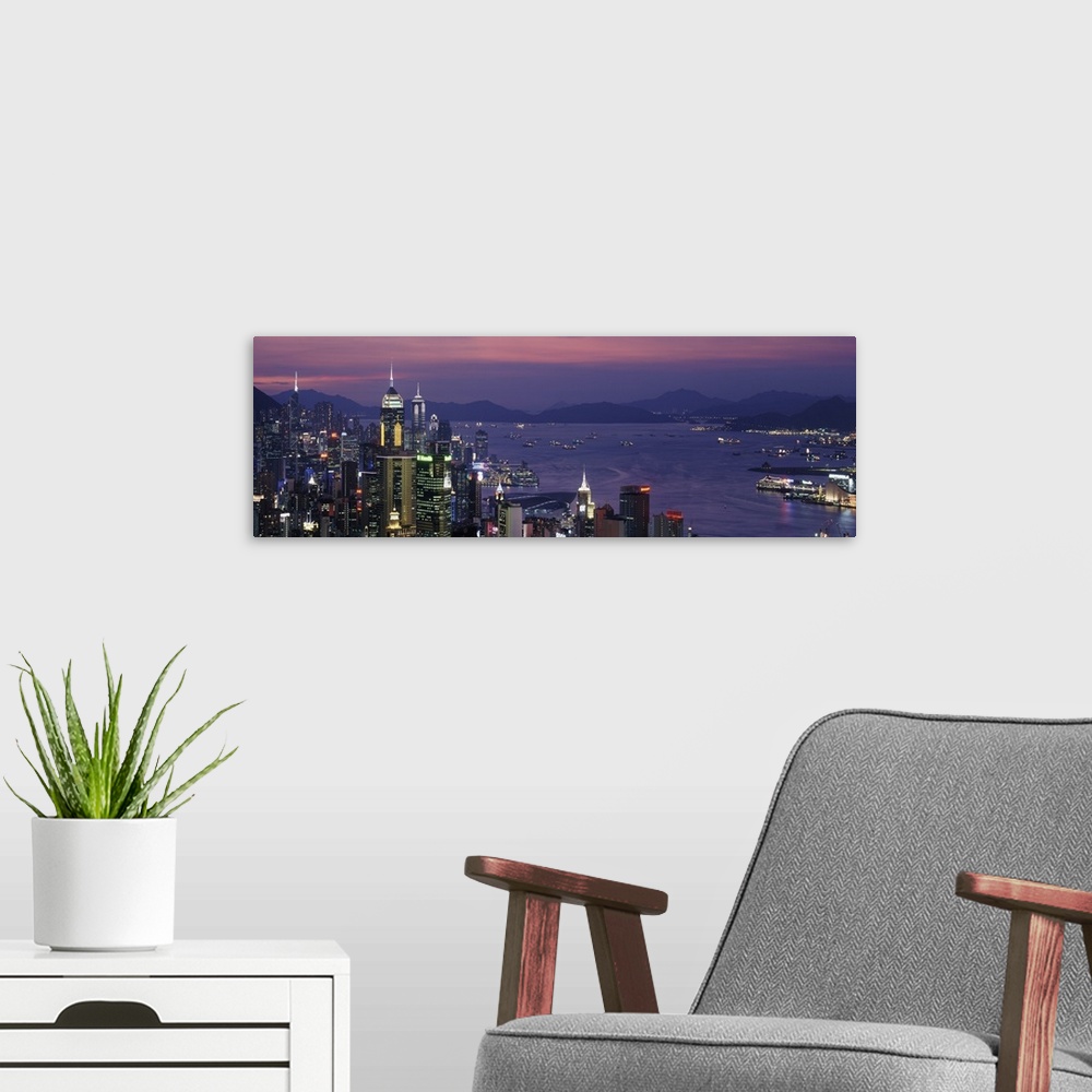 A modern room featuring Panoramic image of twilight and the Hong Kong skyline and water by the city.