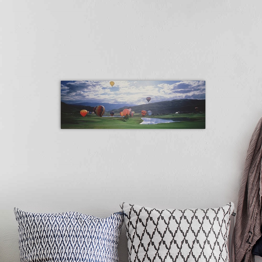 A bohemian room featuring This is a landscape photograph of hot air balloons lifting off from a field on the valley floor i...