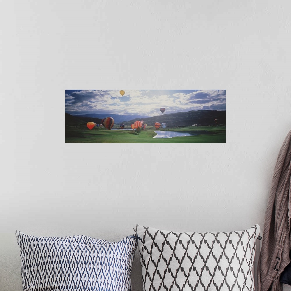 A bohemian room featuring This is a landscape photograph of hot air balloons lifting off from a field on the valley floor i...