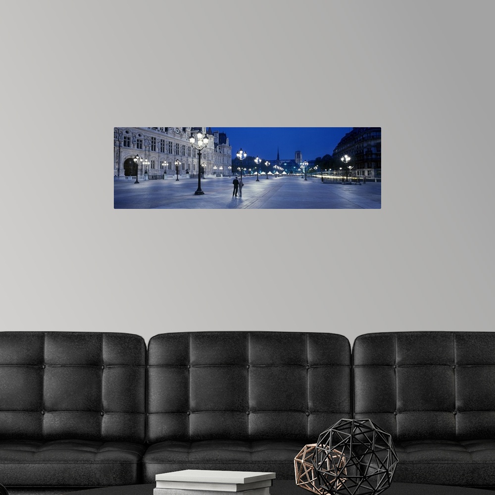 A modern room featuring Panoramic image of a street outside the Hotel de Ville lit up at night in Paris, France.