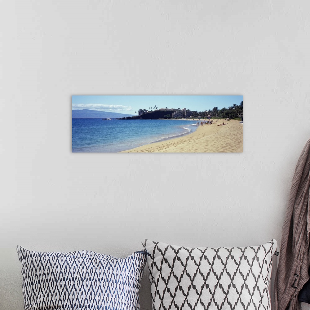 A bohemian room featuring Wide angle photograph taken of a Hawaiian coast with people on the beach and a hotel in the dista...