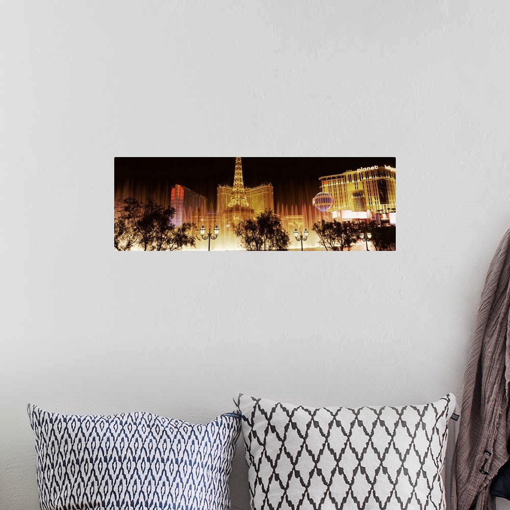 A bohemian room featuring Panoramic photograph of ""Sin City"" skyline and Bellagio fountains with tree and street lamp sil...