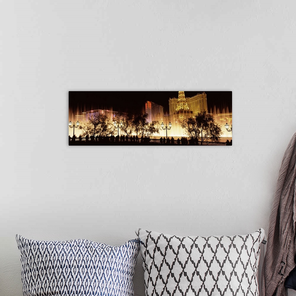 A bohemian room featuring Large panoramic photograph of the Las Vegas strip lit up with the silhouette of people and trees ...