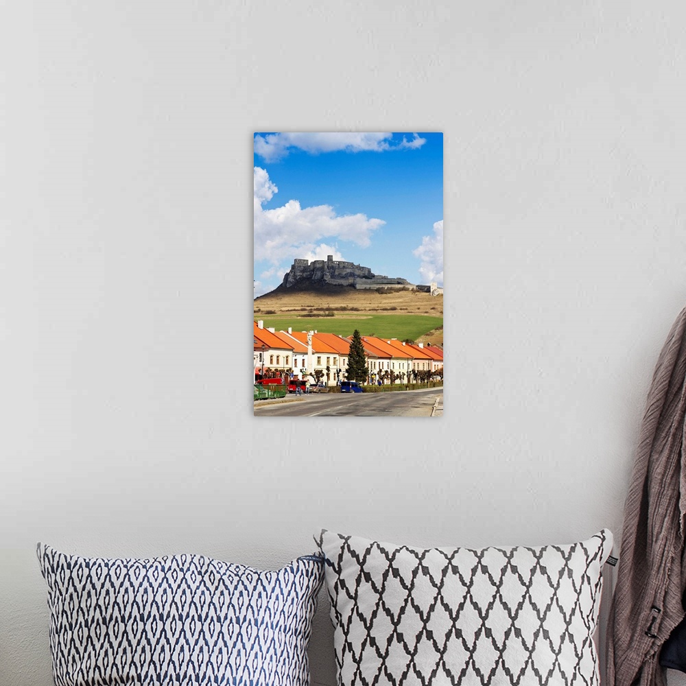 A bohemian room featuring Houses along a road with a castle in the background, Slovakia