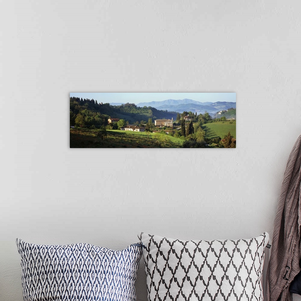 A bohemian room featuring Giant, landscape photograph of rolling green hills and tress surrounding several houses in Marche...